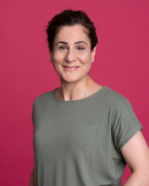 Portrait of Azina Barzideh against a magenta background