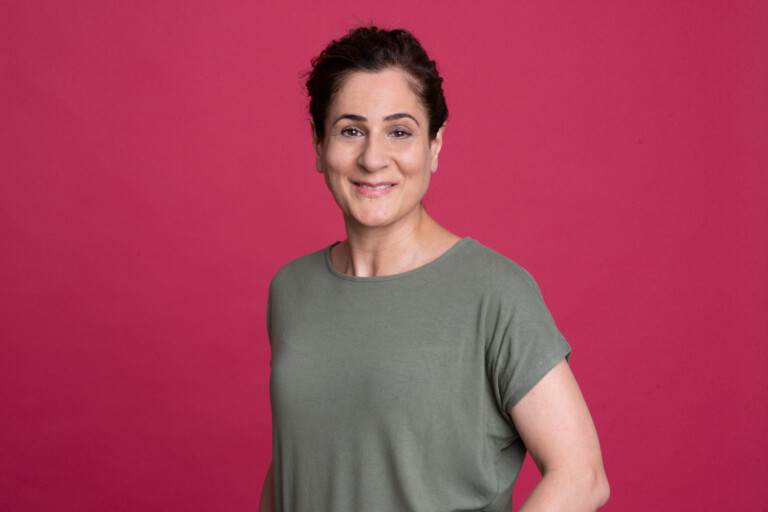 Portrait of Azina Barzideh against a magenta background