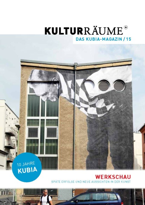 Cover der Kulturräume+ 15/2018. Foto des französischen Fassadenkünstlers JR von dem Projekt "The Wrinkles of the City". Schwarz-Weiß Porträt eines gebeugten älteren Manns mit Rauten-Pullunder, das überlebensgroß auf die Fassade eines Berliner Gebäudes aufgebracht ist.