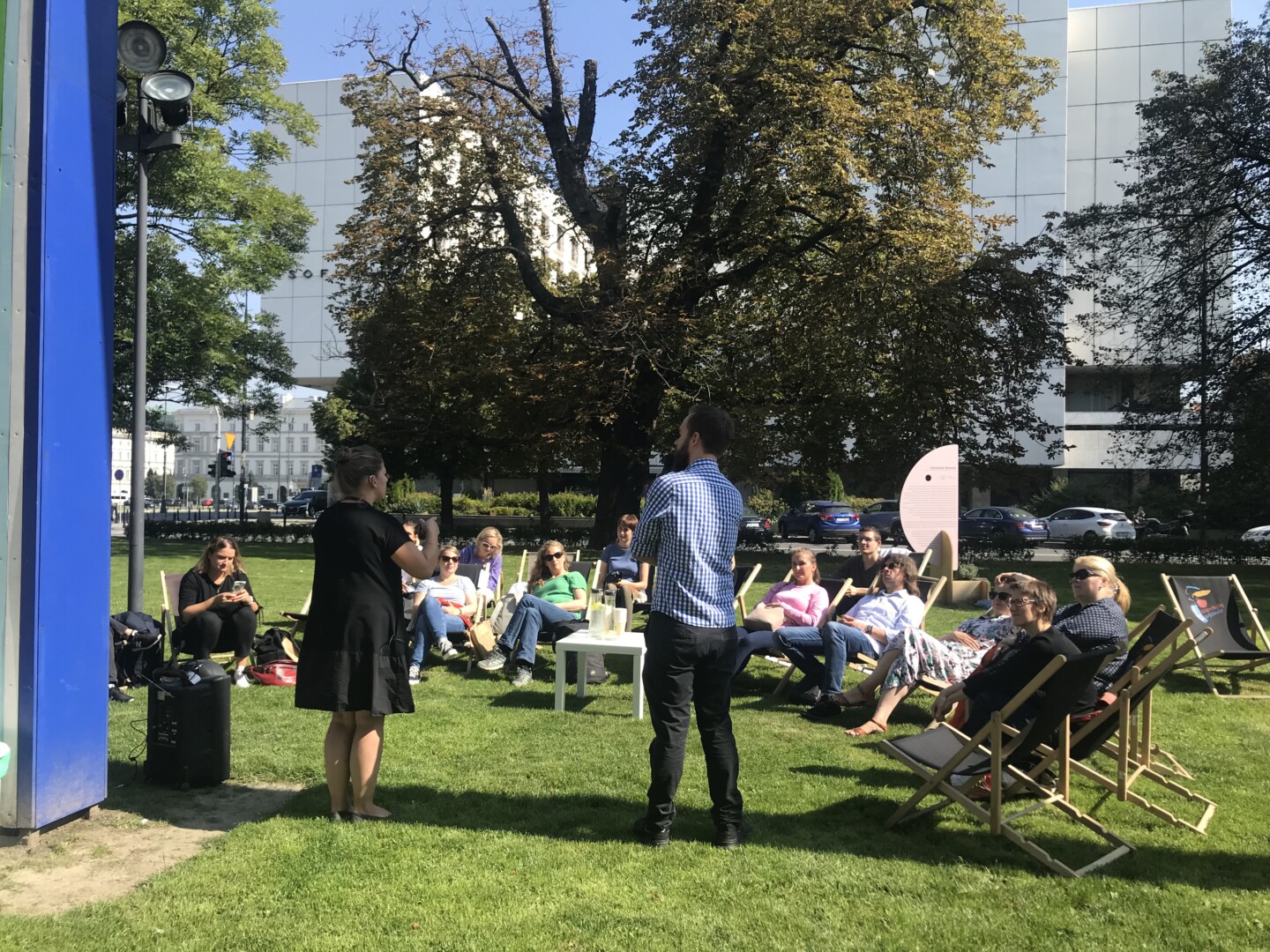 Die deutsch-polnische Projektgruppe von "Culture without barriers" bei einer Präsentation von Mitarbeiter*innen der Nationalgalerie Zachęta, Warschau, auf dem Vorplatz des Museums im Sommer 2022