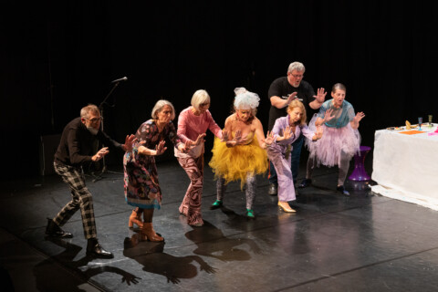 Eine Gruppe von älteren Menschen, die auf einer Bühne tanzen.