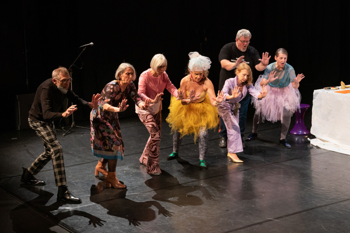 A group of elderly people dancing on a stage.