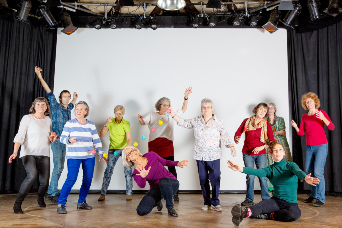 A group of elderly women posing for a photo with dancing gestures