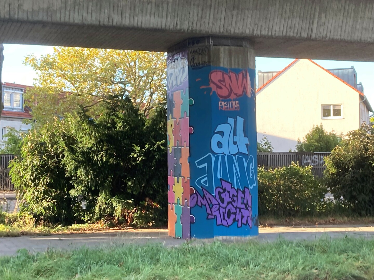 A bridge pier made of concrete with graffiti on it with the inscription "Alt - Jung - Oma gegen rechts" ("Old - Young - Grandma against the right")