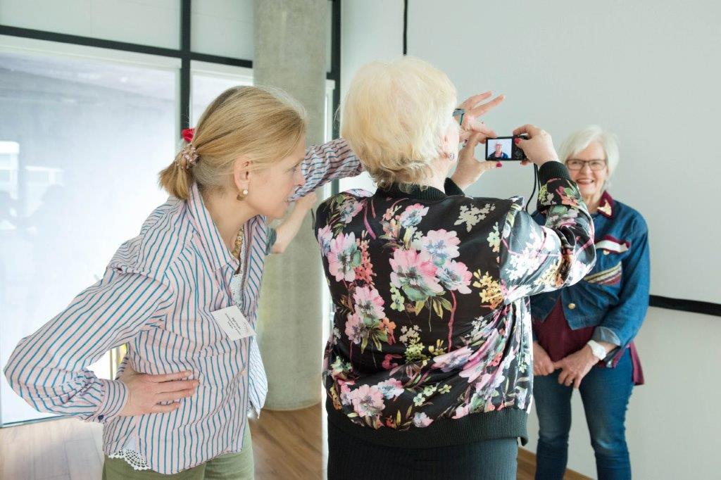 Eine ältere Frau macht mit dem Handy ein Foto von einer anderen Älteren. Eine Kulturvermittlerin gibt Tipps dazu.