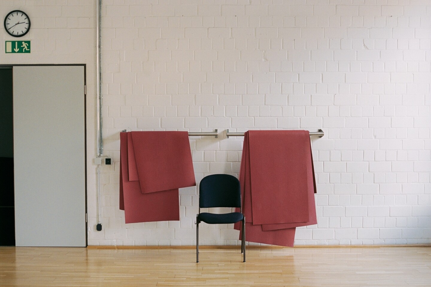 A chair and a red blanket on a ballet barre