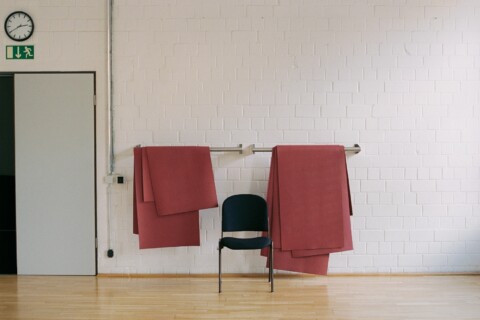 Ein Stuhl und eine rote Decke auf einer Ballettstange