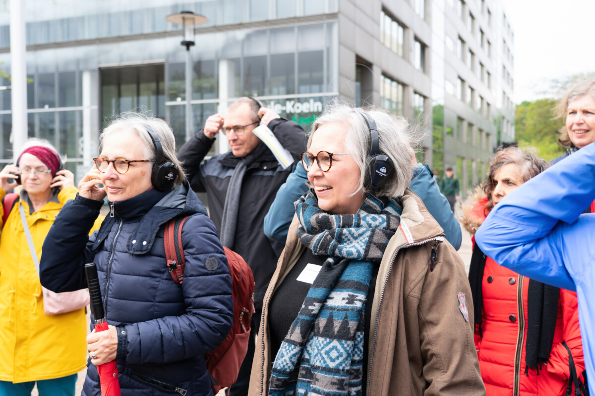 Eine Gruppe von Menschen mit Kopfhörern, die nach draußen gehen