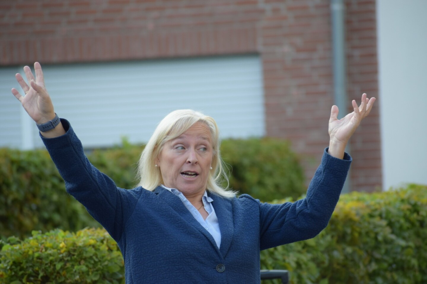 Eine Frau, die ihre Arme seitlich in die Luft streckt