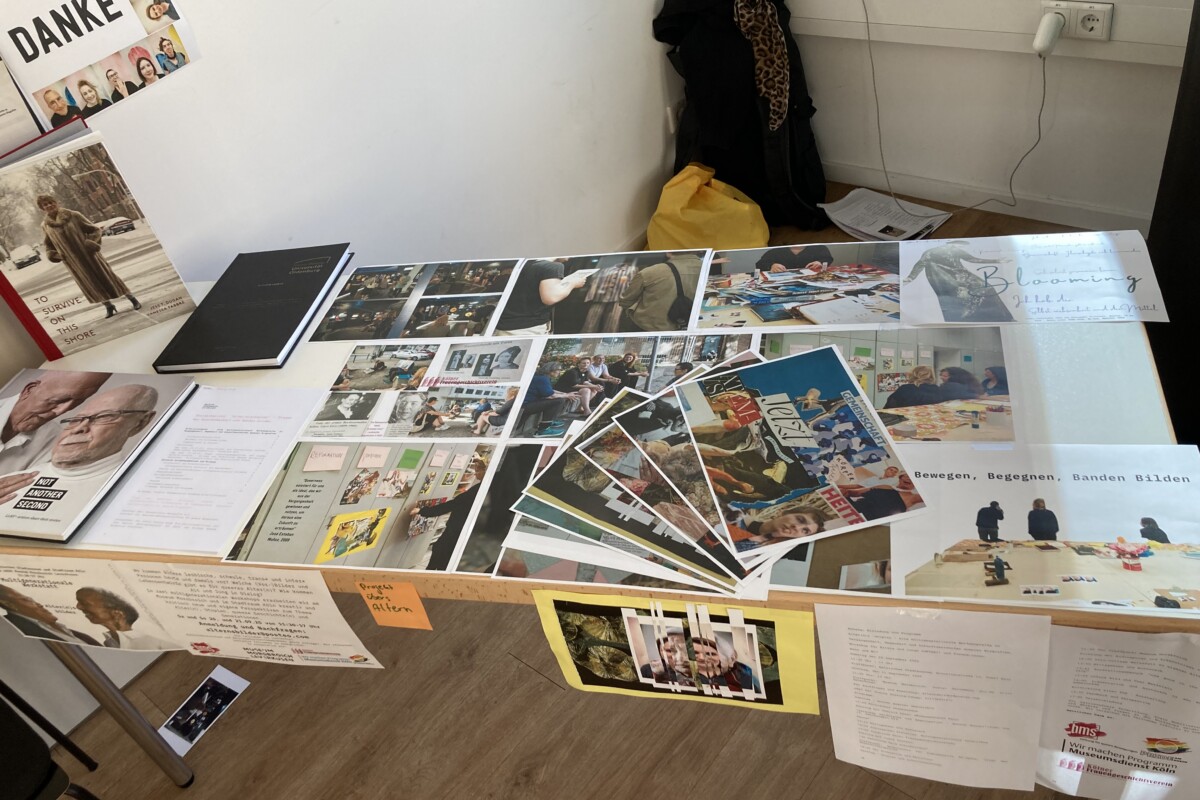 Auf einem Tisch liegen Materialien und Collagen zu queeren Lebensläufen, die mit den Teilnehmenden entstanden sind.