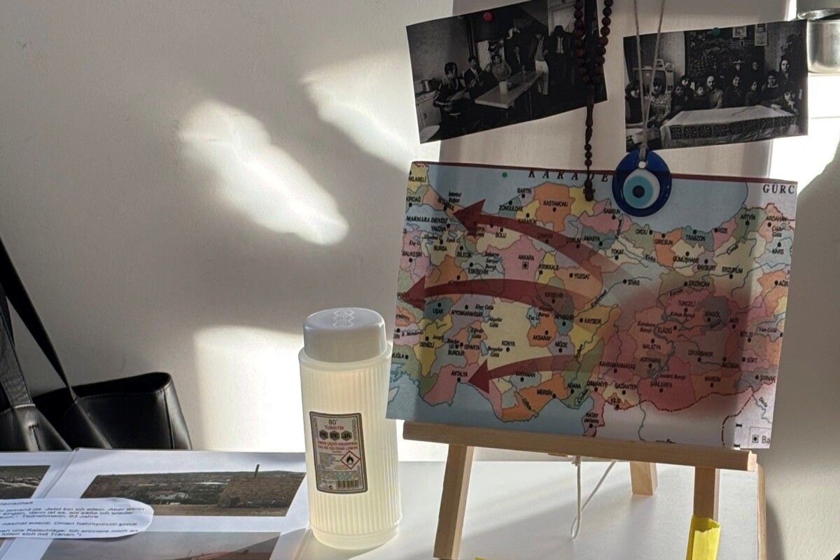 Tisch mit historischen Fotos, einer Landkarte und Materialien zur musikalischen Arbeit mit kurdischen Senior*innen der ersten Gastarbeitergeneration