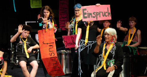 Im Rat der Generationen erproben Jugendliche und Ältere performativ demokratische Prozesse. Sie zeigen Schilder mit "Einspruch" oder "Ordnungsruf".